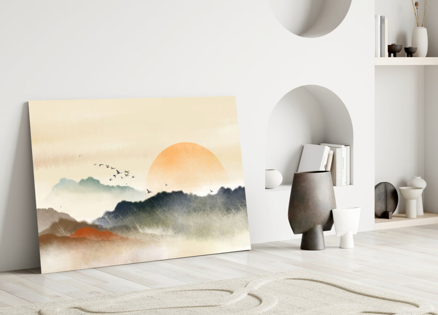 Abstract landscape glass art leaning against white wall displays misty mountains, orange sun, and flying birds in muted earth tones.