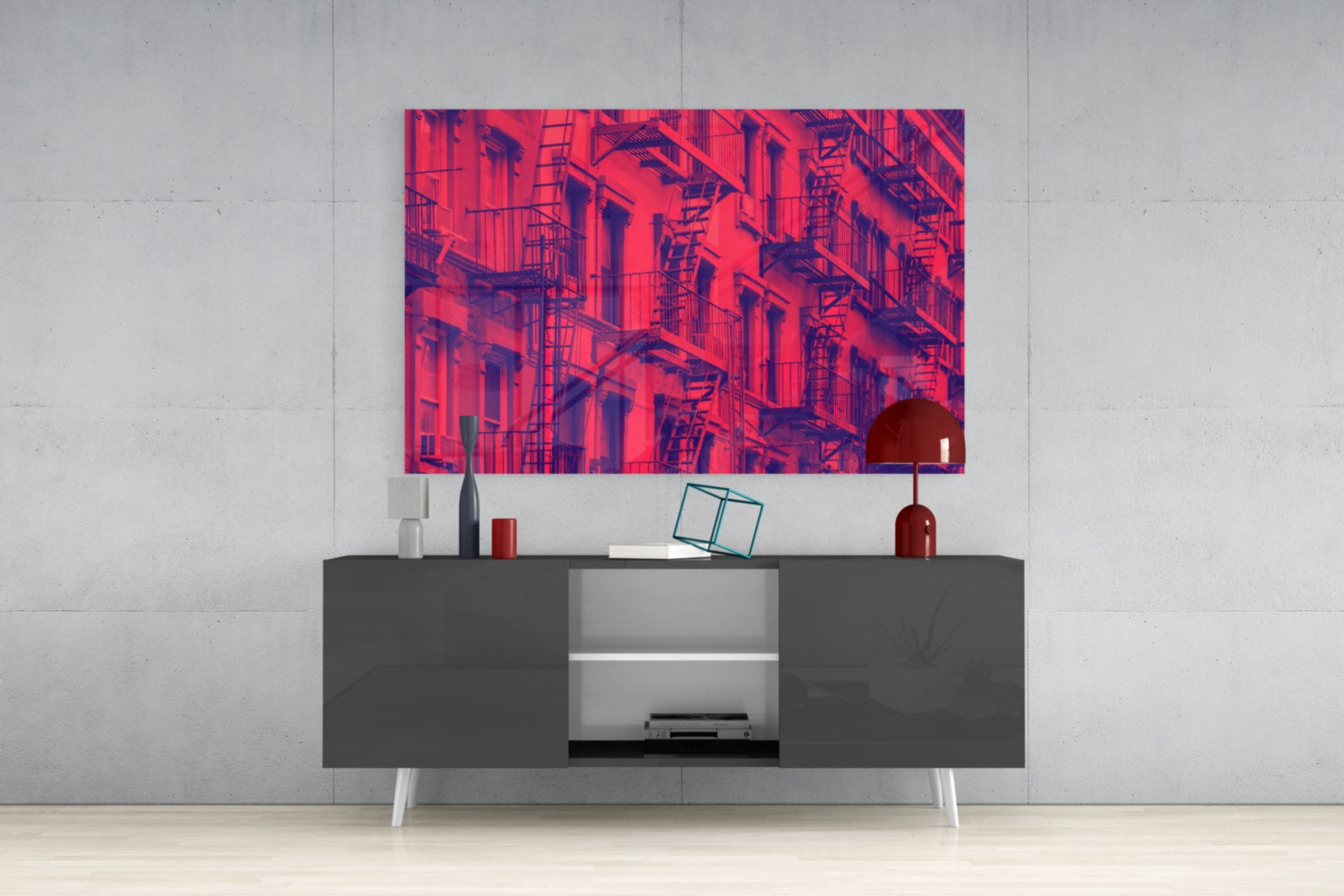 Red and purple glass wall art depicting a geometric building facade with fire escapes displayed above a dark modern console table.