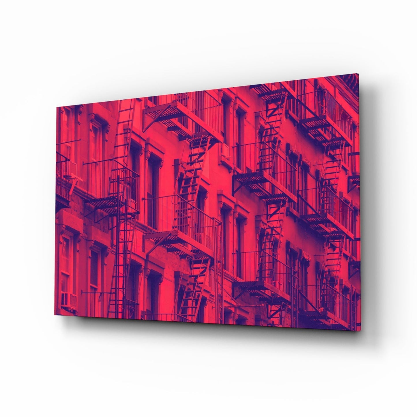 Red and purple tinted glass wall art featuring a building facade with fire escapes and windows, displayed at an angle.