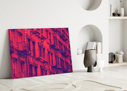Vibrant red and purple thermal-style urban building facade glass wall art leaning against white interior wall.