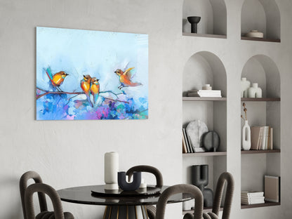 Colorful glass wall art depicting three yellow and orange birds perched on a branch above blue and purple watercolor splashes, displayed in a modern dining room setting.