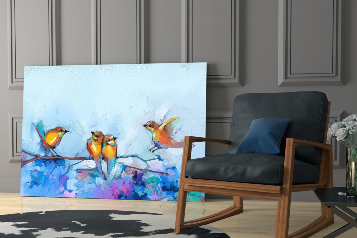 Colorful glass wall art depicting three orange and yellow birds on a branch with blue and purple floral elements, displayed in a modern living room setting.