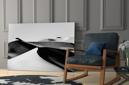 Black and white landscape glass wall art displayed in modern interior with wooden chair and paneled wall backdrop.