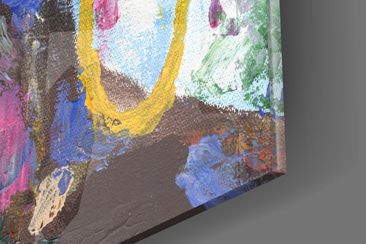 Close-up side view of colorful glass wall art showing layered paint strokes in blue, yellow, pink, green, and brown on textured surface.