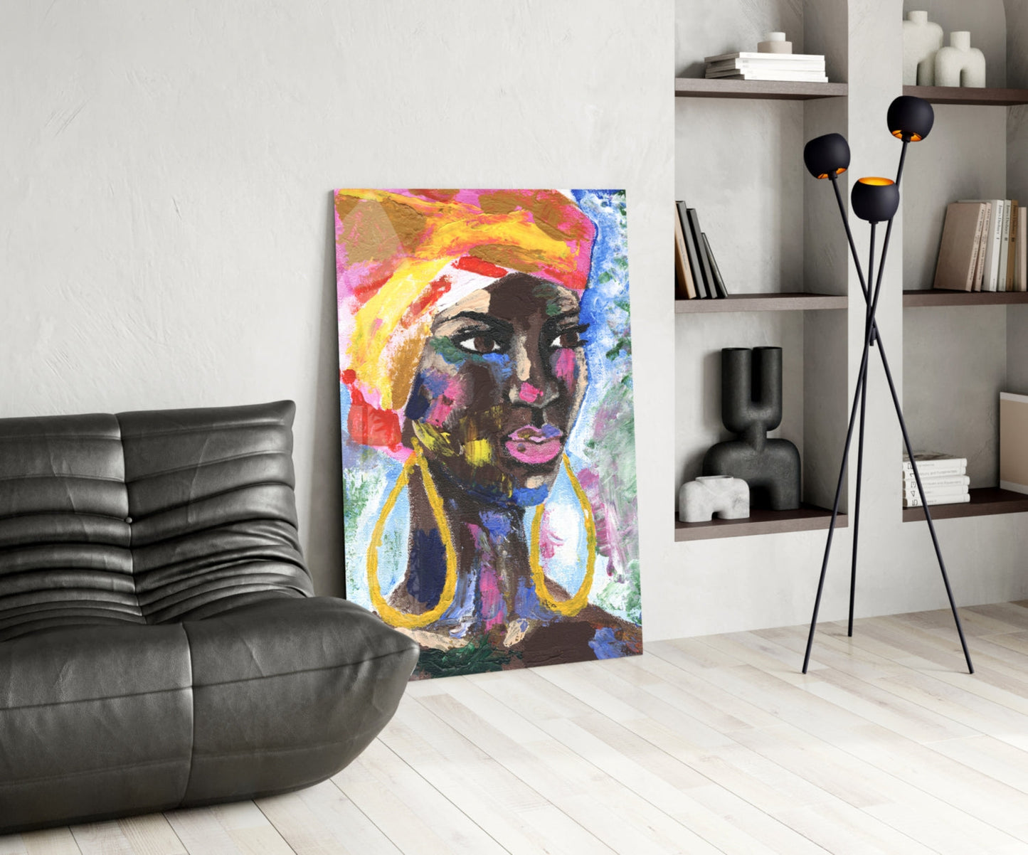 Colorful pop art portrait of woman with yellow headwrap and dangling earrings displayed in modern living room with black sofa and shelving.