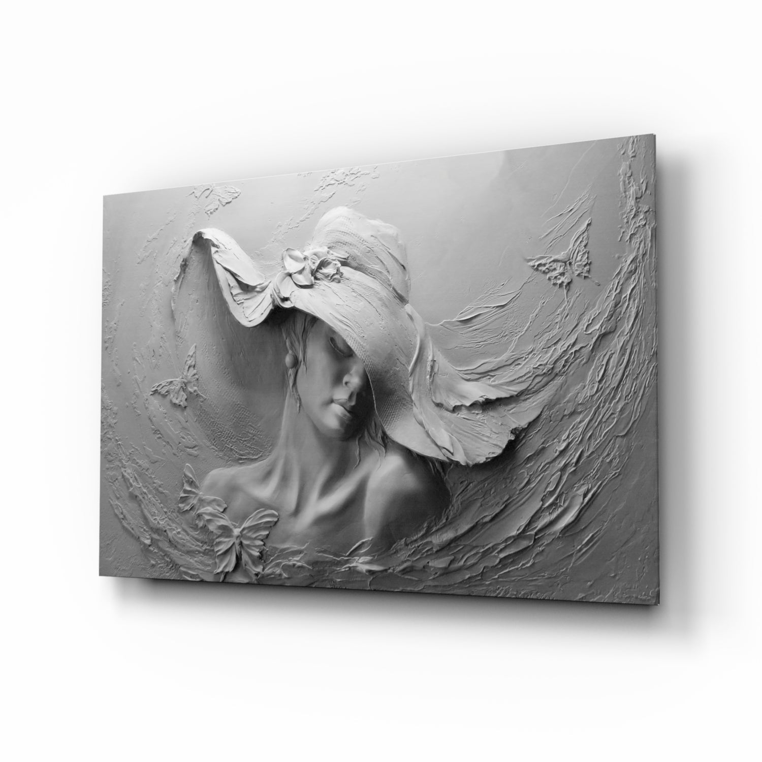 Three-dimensional white relief sculpture of a woman wearing a wide-brimmed hat with flowing fabric, displayed against neutral background.