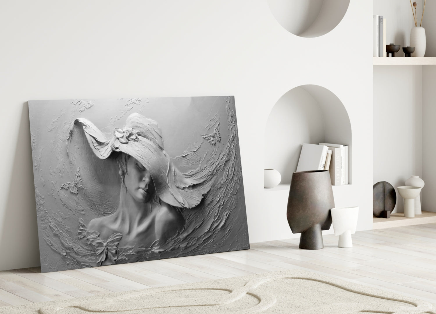 Gray relief glass wall art depicting a woman's profile with flowing hair displayed against a white interior wall with decorative shelving.