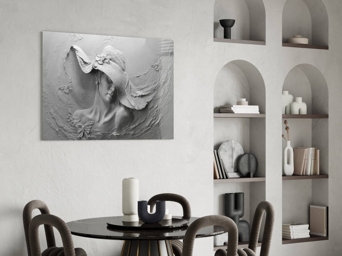White relief sculpture of a woman's profile with flowing hair mounted on wall above black dining table with gray chairs and built-in shelving.