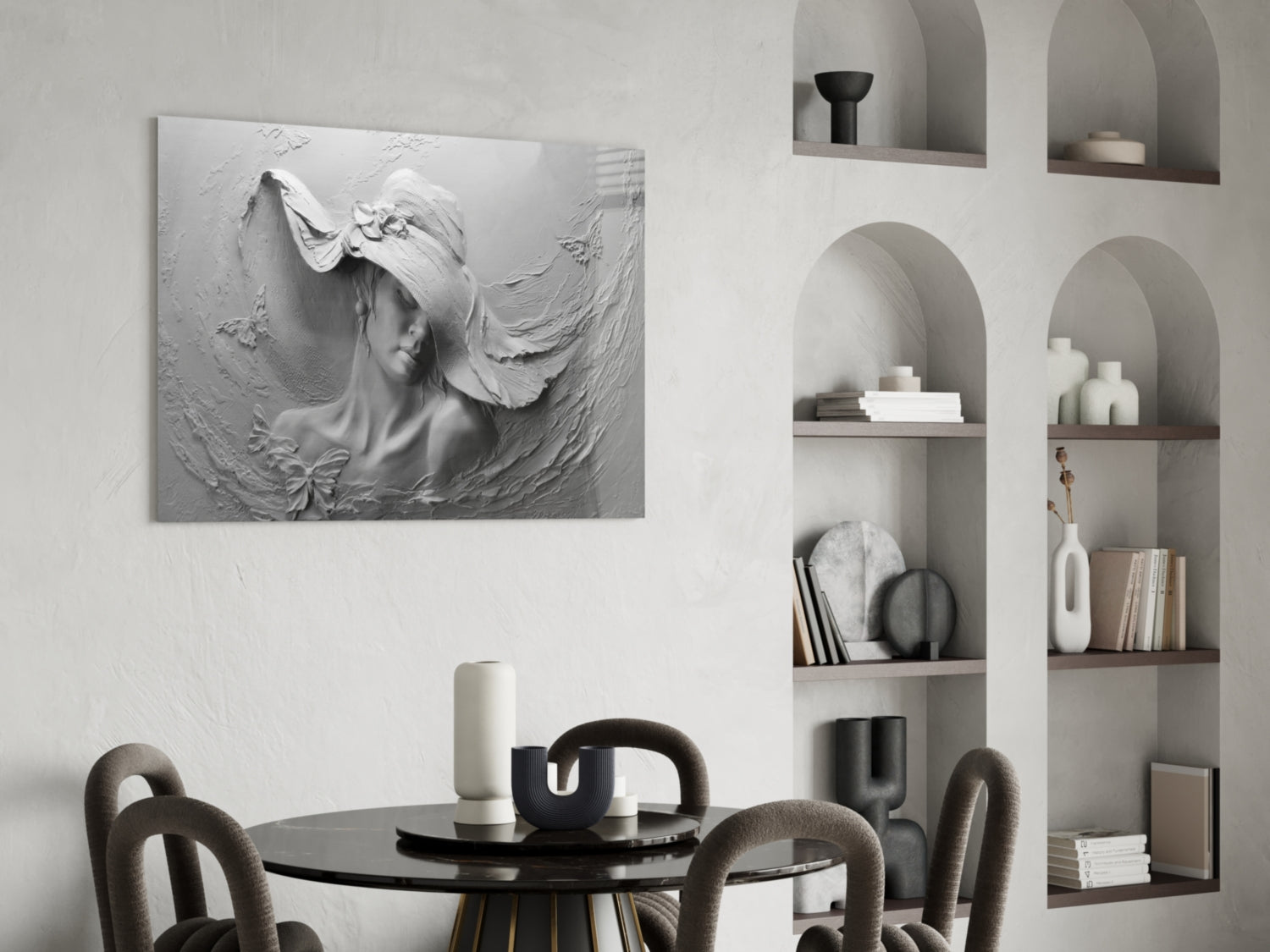 White relief sculpture of a woman's profile with flowing hair mounted on wall above black dining table with gray chairs and built-in shelving.