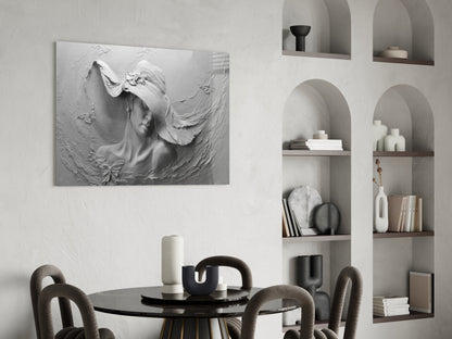 White relief sculpture of a woman's profile with flowing hair mounted on wall above black dining table with gray chairs and built-in shelving.