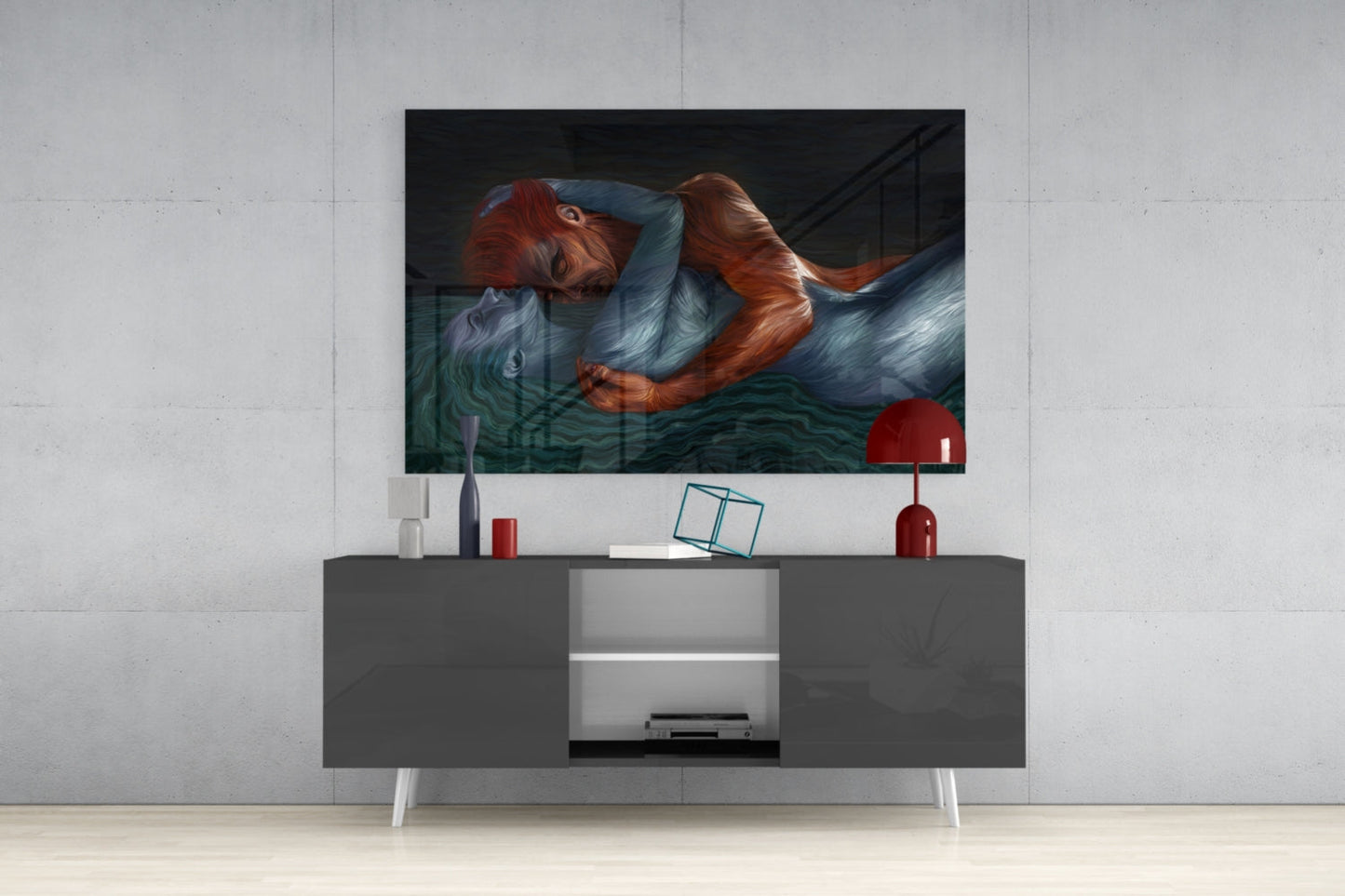 Modern living room with glass wall art depicting a red-haired figure above a dark gray media console with white legs and decorative accessories.