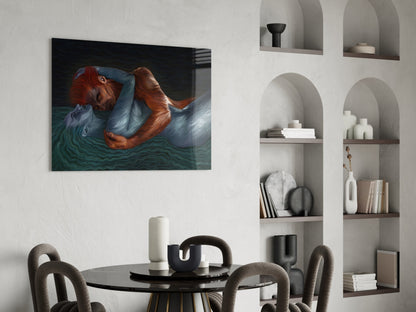 Glass wall art depicting a figure with red hair in blue clothing floating in dark teal water, displayed above a black dining table.