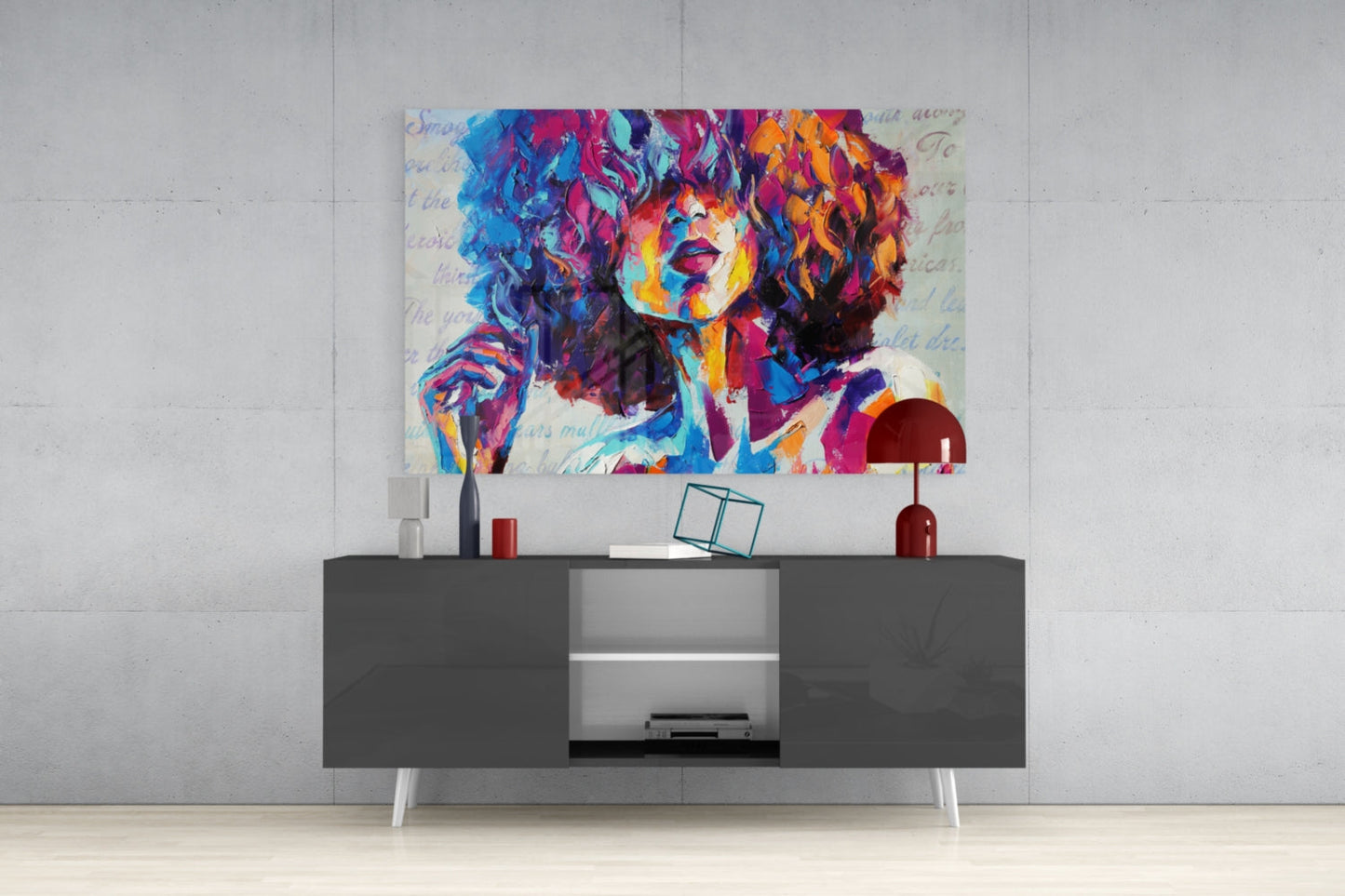 Vibrant multicolored abstract portrait glass art displayed above modern gray media console with white legs and shelving.