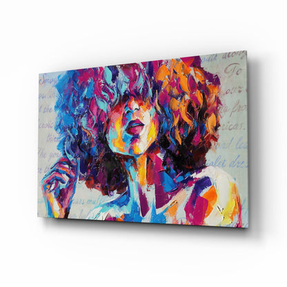Colorful abstract portrait on glass with vibrant blue, magenta, orange, and yellow brushstrokes and faint text overlay, displayed at an angle.