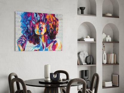 Colorful pop art portrait canvas hanging above a round black dining table with upholstered chairs and white built-in shelving.