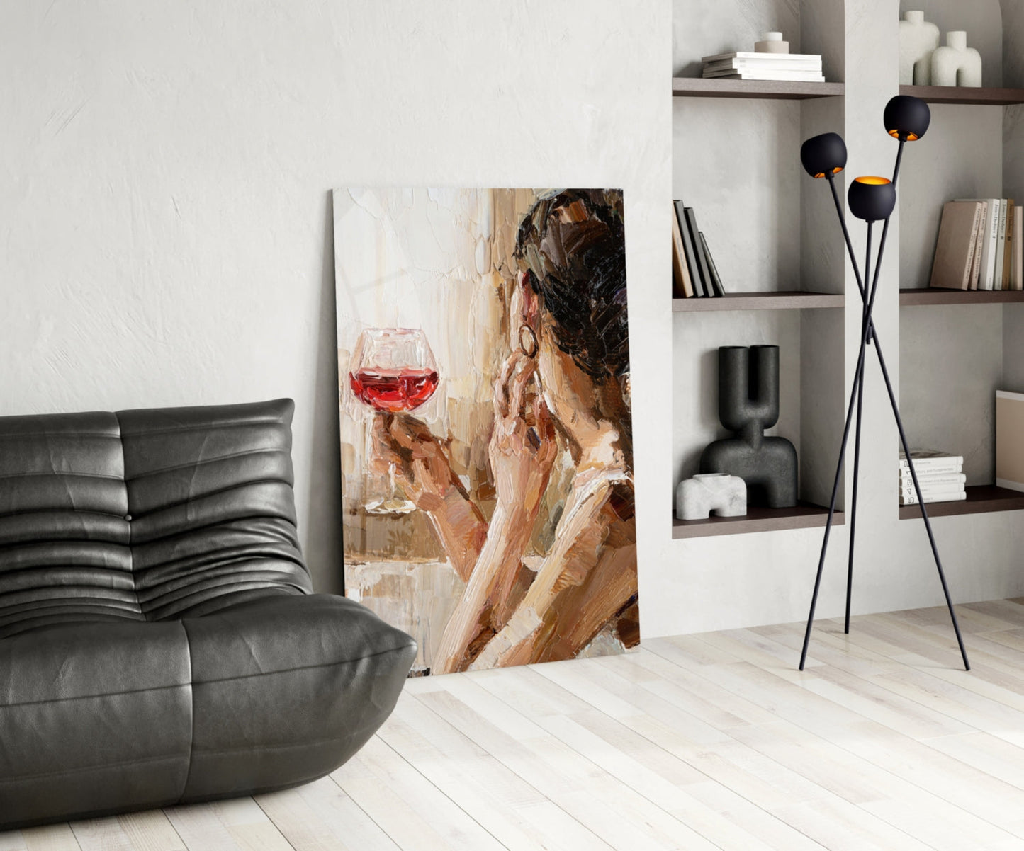 Wine and Women glass art canvas displayed in modern living room with black leather sofa and shelving.
