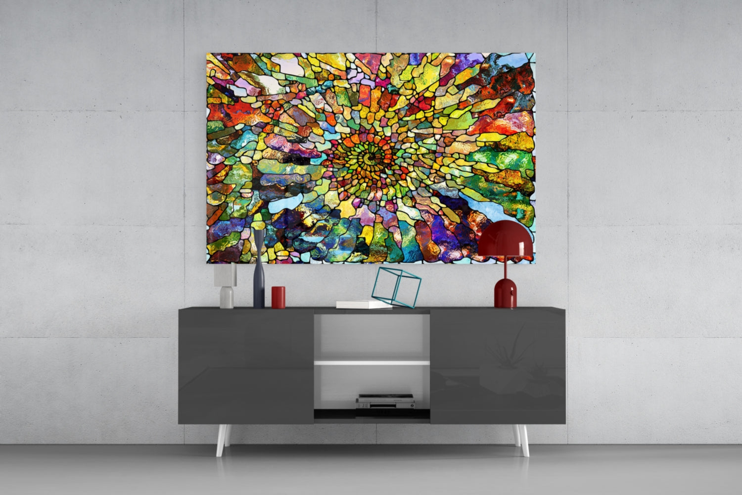 Vibrant multicolored mosaic glass art with concentric spiral pattern displayed above gray media console in modern interior setting.