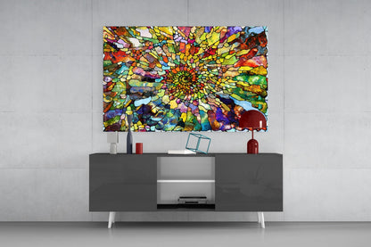 Vibrant multicolored mosaic glass art with concentric spiral pattern displayed above gray media console in modern interior setting.