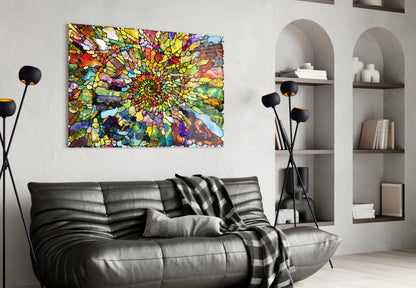 Vibrant multicolored mosaic glass art with concentric circular pattern displayed above black leather sofa in modern living room.