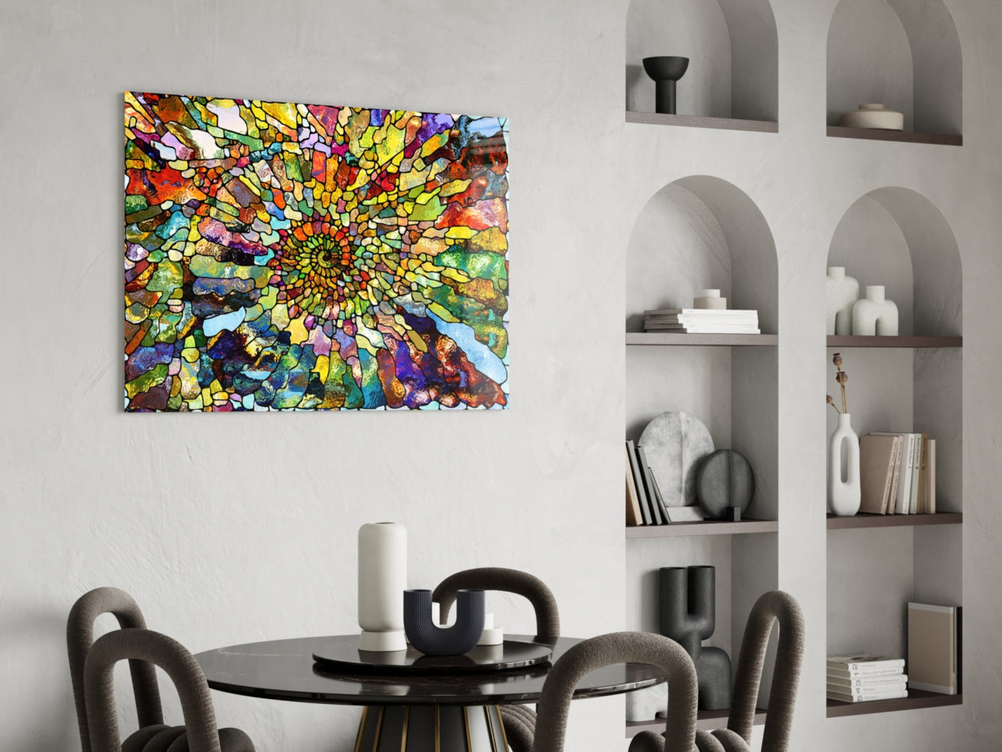 Vibrant stained glass mosaic artwork with yellow, blue, red, and green geometric patterns displayed above a round black dining table with upholstered chairs.