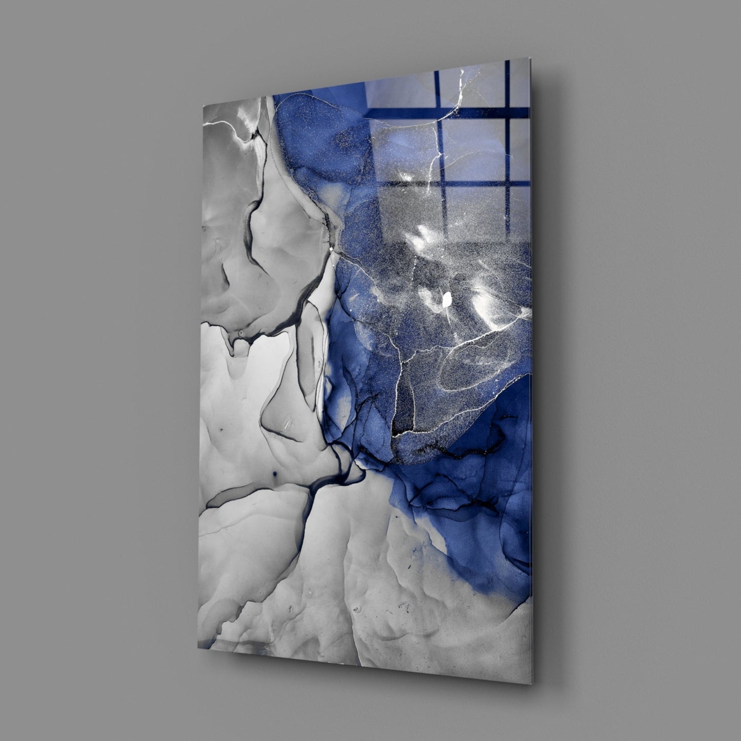 Abstract glass art panel featuring swirling blue and white resin with metallic gold veining and grid pattern overlay, photographed at angle against gray background.