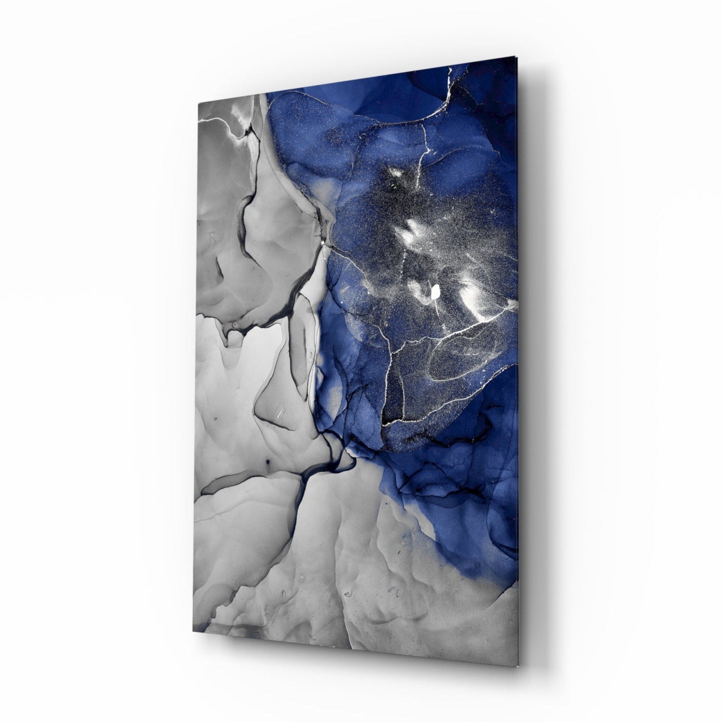Abstract glass panel with deep blue and gray swirled patterns separated by white veining, mounted at angle.