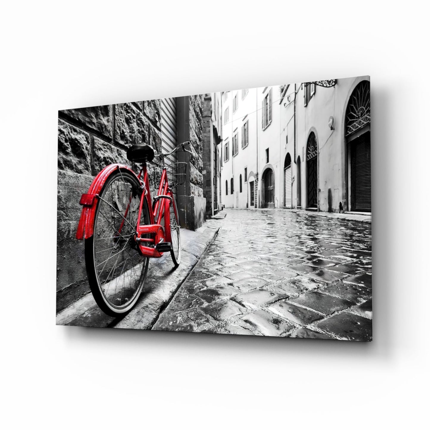Red vintage bicycle leaning against stone wall in monochrome European street alley, displayed as angled glass art print.