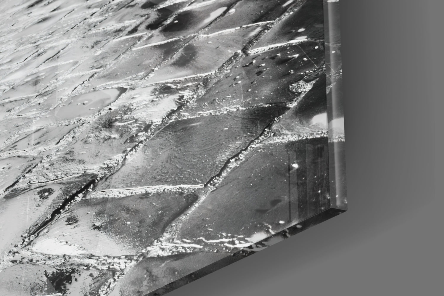 Close-up of textured glass surface with white and gray streaked patterns and a metal frame edge visible on the right side.