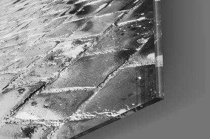 Close-up of textured glass surface with white and gray streaked patterns and a metal frame edge visible on the right side.