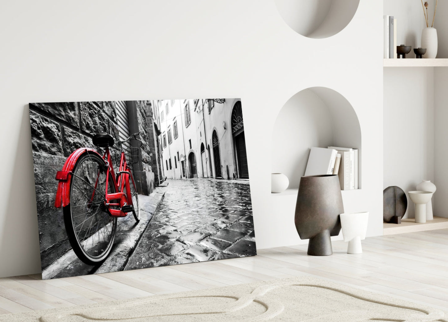 Red bicycle leaning against gray stone wall in black and white street scene glass art displayed in modern interior setting.