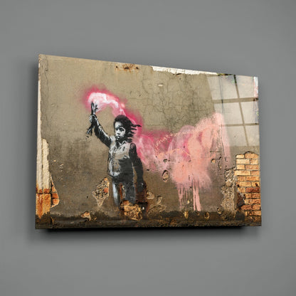 Glass art print mounted on weathered concrete wall showing stenciled child figure holding pink powder explosion, with exposed brick visible at edges.