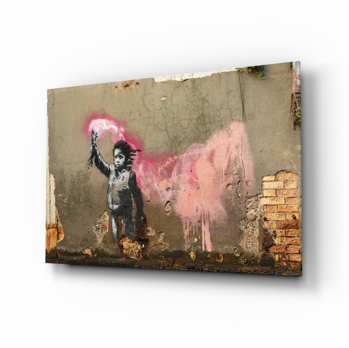 Glass art print of stenciled child figure holding pink spray paint can against weathered concrete wall with exposed brick.