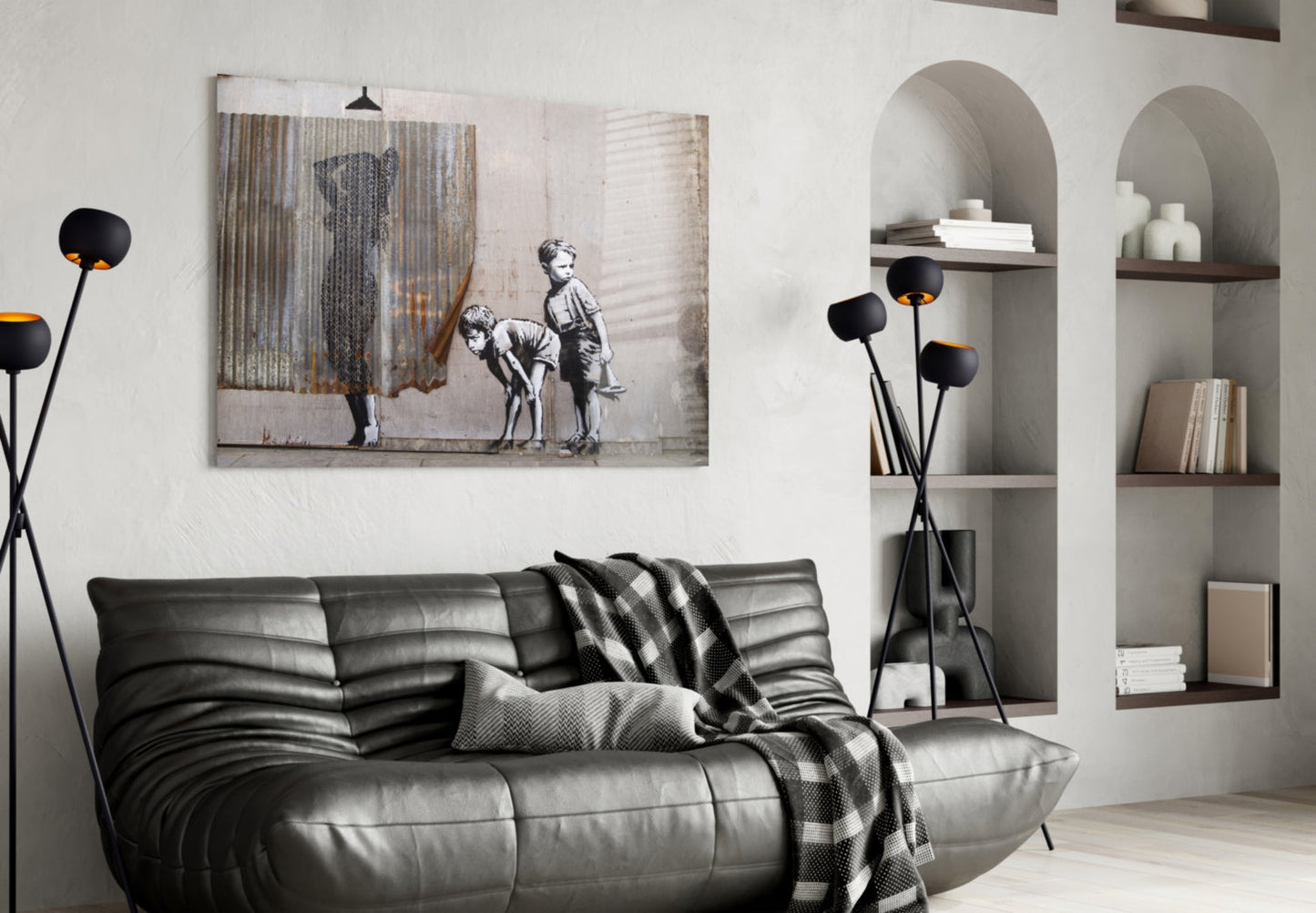 Modern living room with black leather sofa, arched wall alcoves, black floor lamp, and framed street art print above furniture.