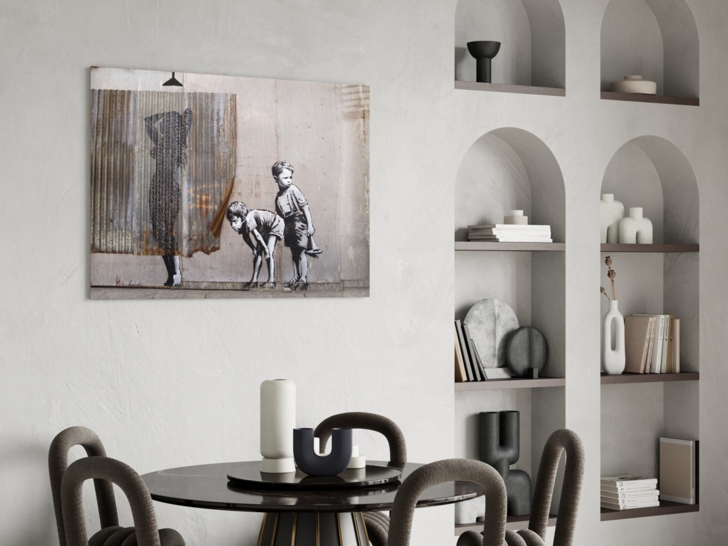 Curiosity glass art print displayed above black round dining table with gray upholstered chairs in modern white interior.