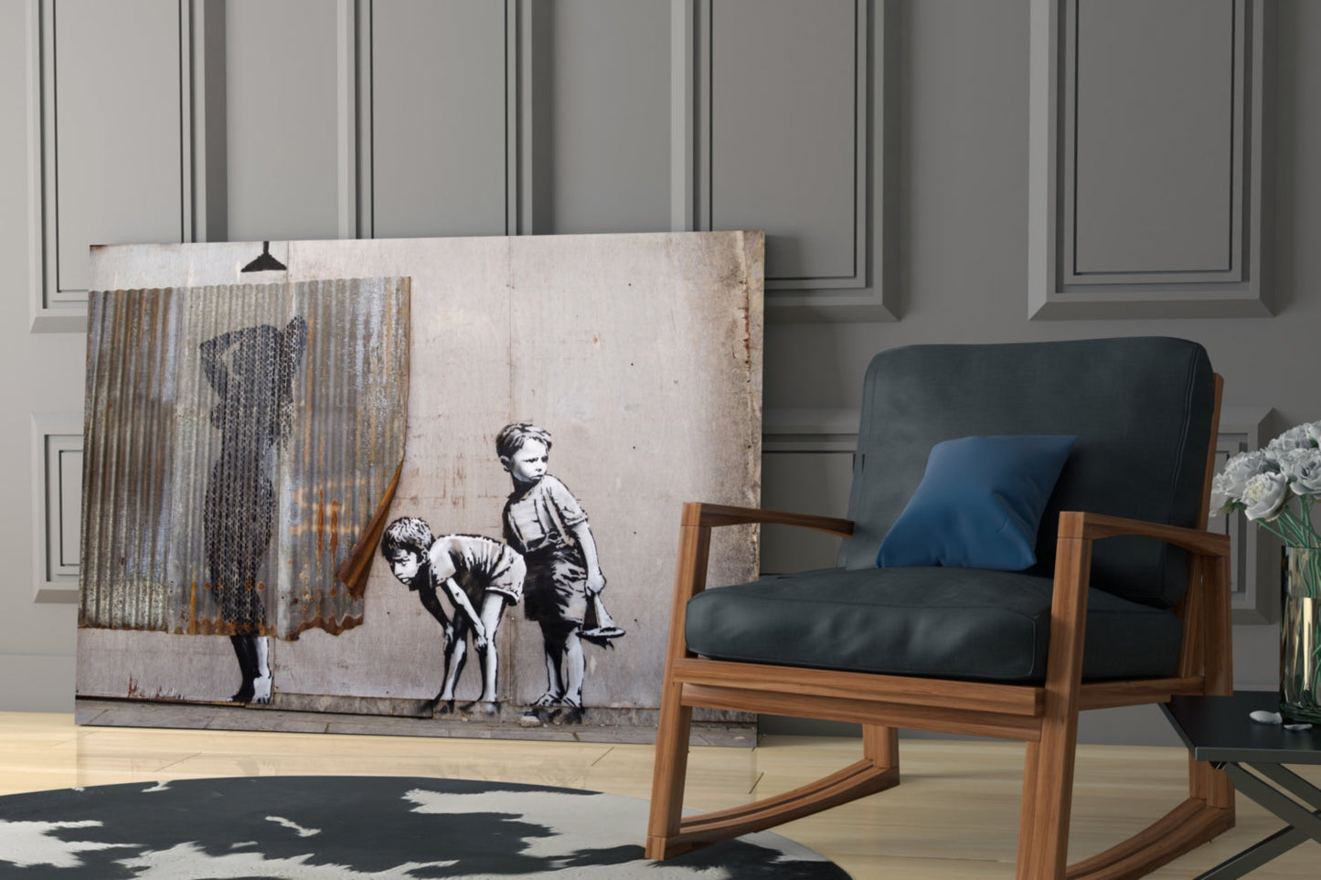 Banksy-style street art glass print depicting two children with curtain, displayed leaning against gray wall next to wooden chair.