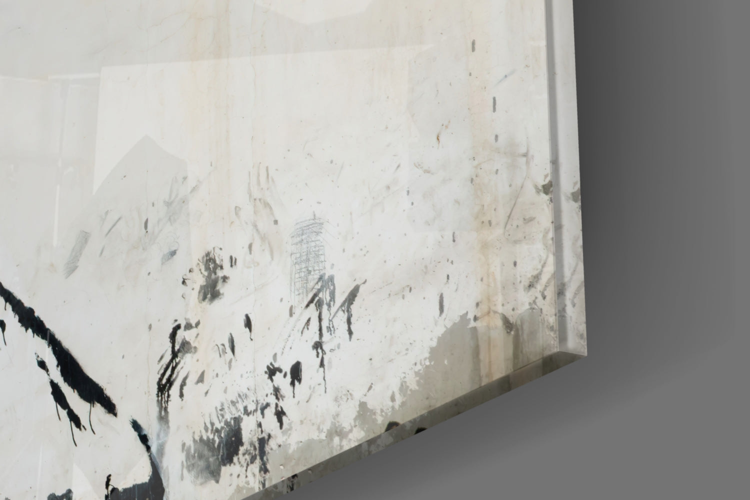 Close-up angled view of Transverse War Glass Art showing layered white and charcoal abstract marks on translucent glass surface.