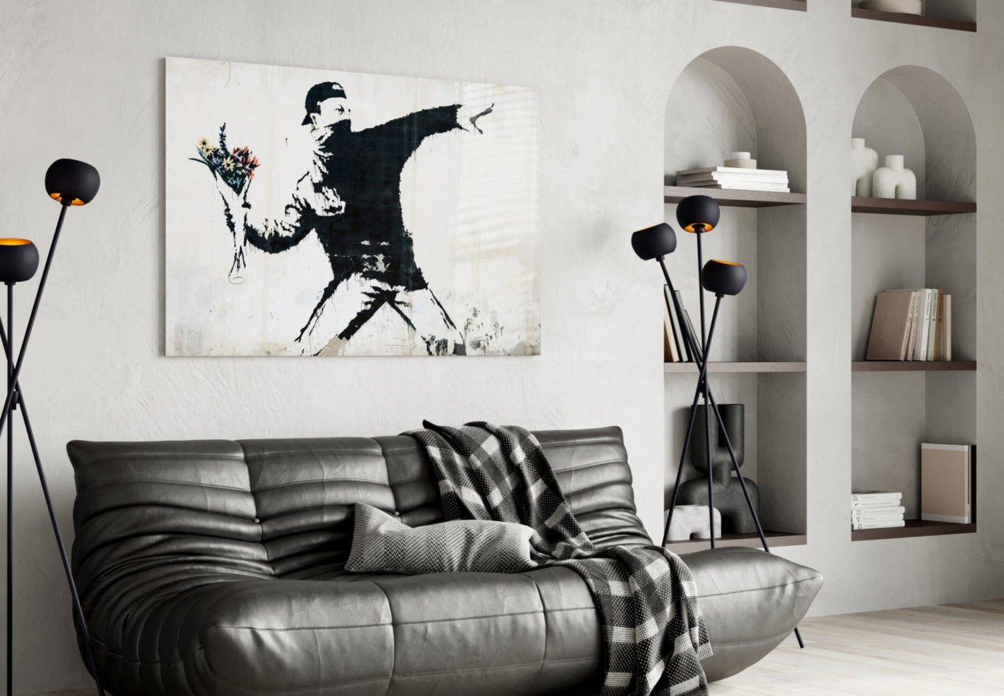 Modern living room with black leather sofa displaying stenciled street art canvas of figure throwing flowers above it.