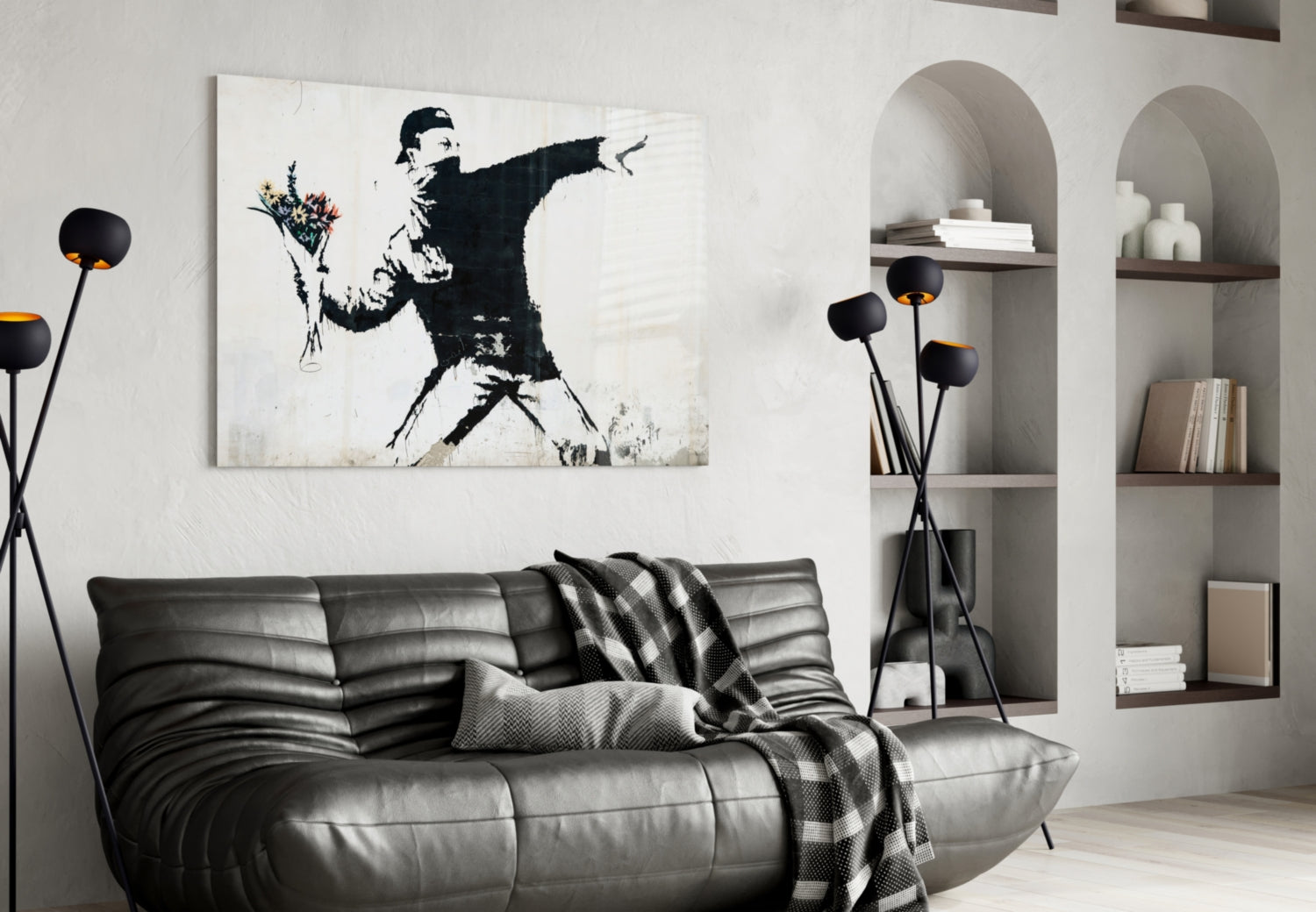 Modern living room with black leather sofa displaying stenciled street art canvas of figure throwing flowers above it.