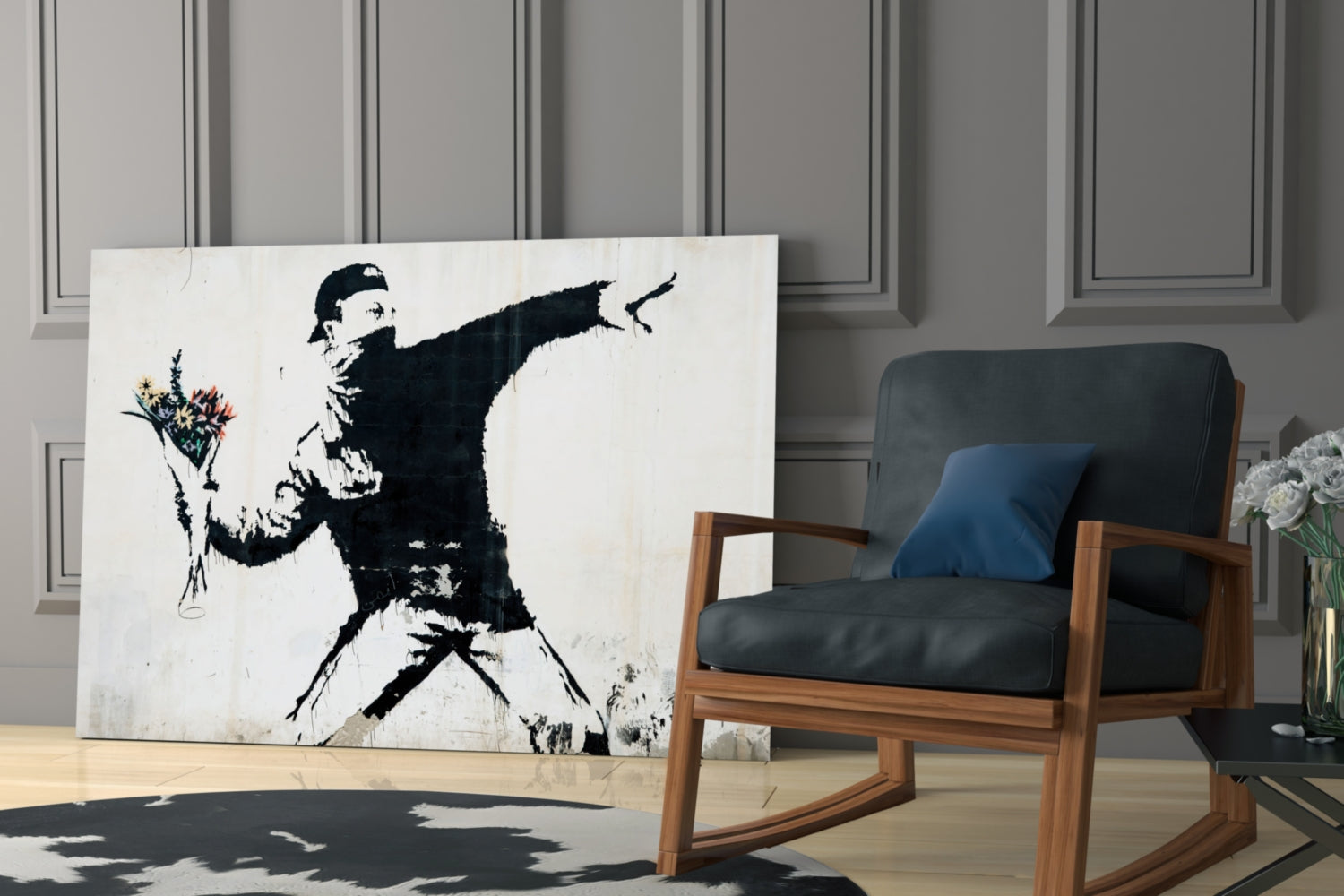Modern living room displaying large black and white stencil art canvas of figure throwing flowers, positioned beside wooden-framed chair.