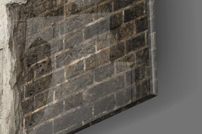 Close-up angled view of weathered dark brick wall texture with mortar joints and light gray surface on left edge.