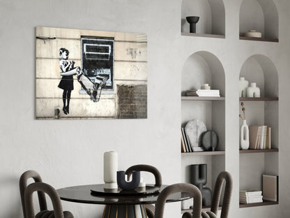 Banksy-style street art canvas displayed above black round dining table with gray upholstered chairs and white arched shelving unit.