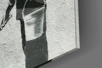 Close-up of textured white glass surface with dark shadow cast by geometric architectural element, showing surface detail and light interplay.