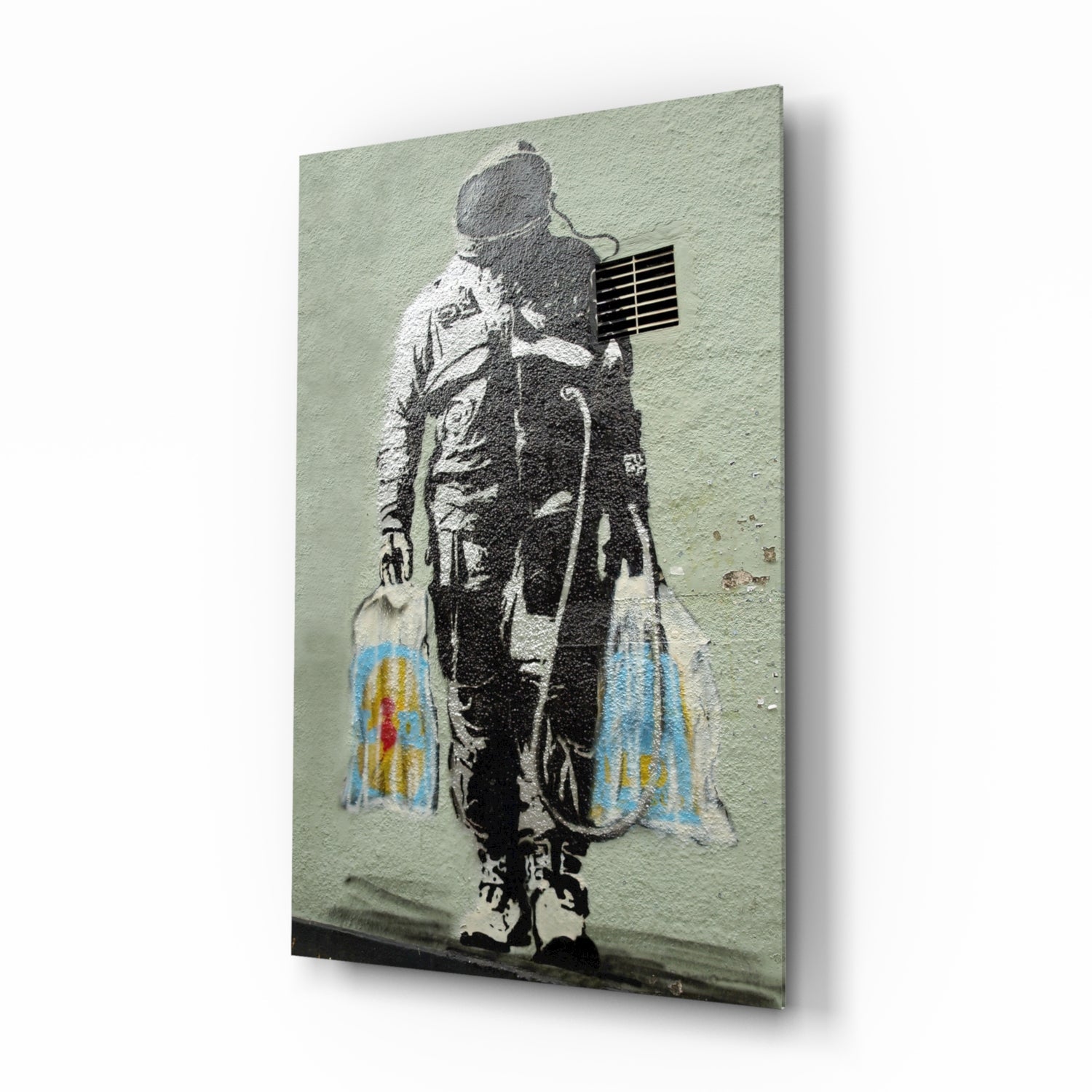 Stenciled astronaut figure carrying colorful shopping bags against pale green textured wall, displayed on glass panel.