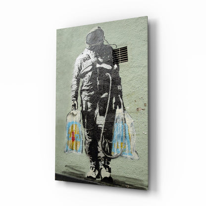 Stenciled astronaut figure carrying colorful shopping bags against pale green textured wall, displayed on glass panel.