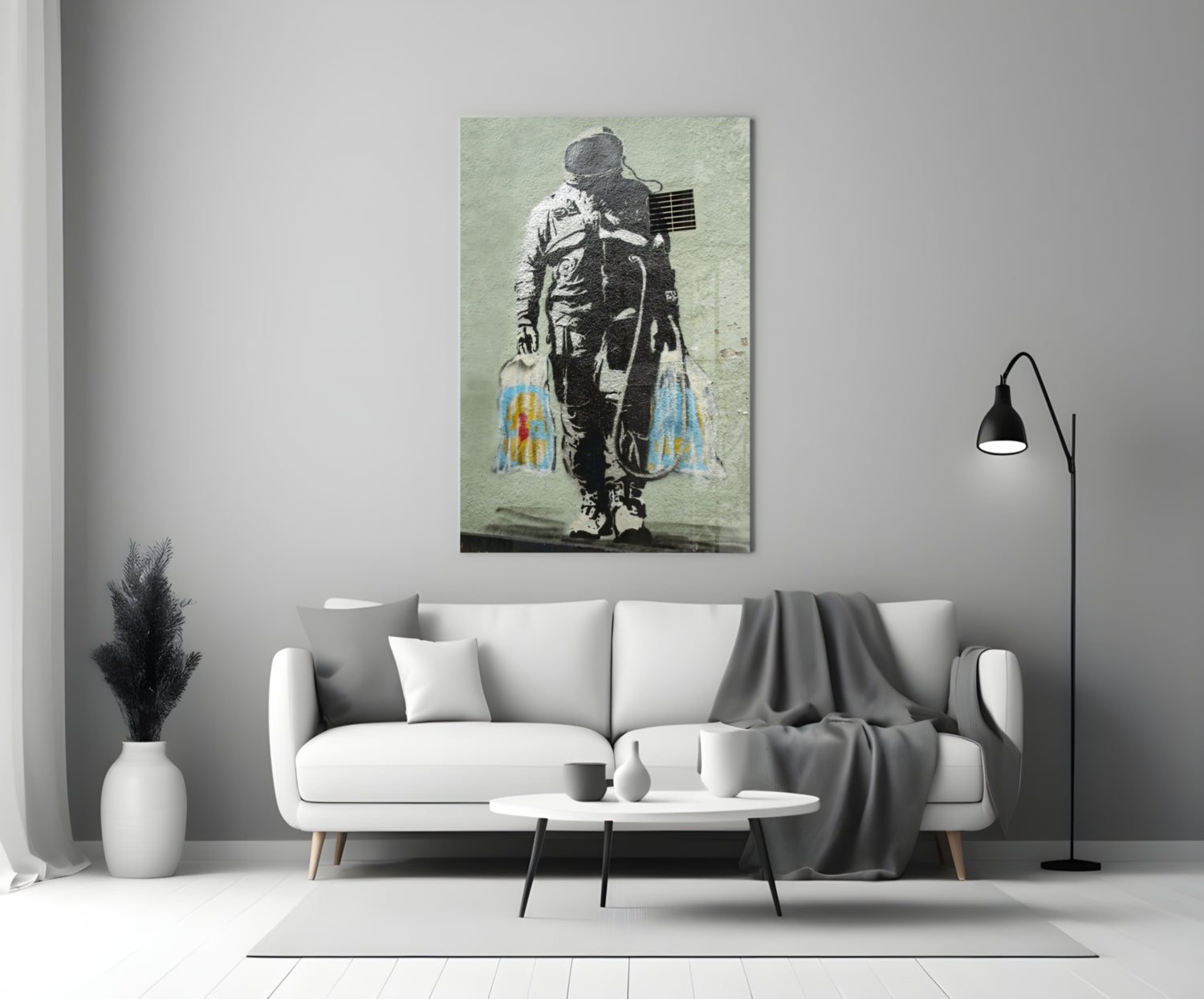 Glass art panel featuring stenciled astronaut with American flag and colorful paint drips displayed above white sofa.