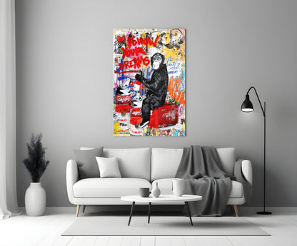 Colorful glass art featuring a black chimpanzee surrounded by red text and Campbell's soup imagery displayed above a white sofa.