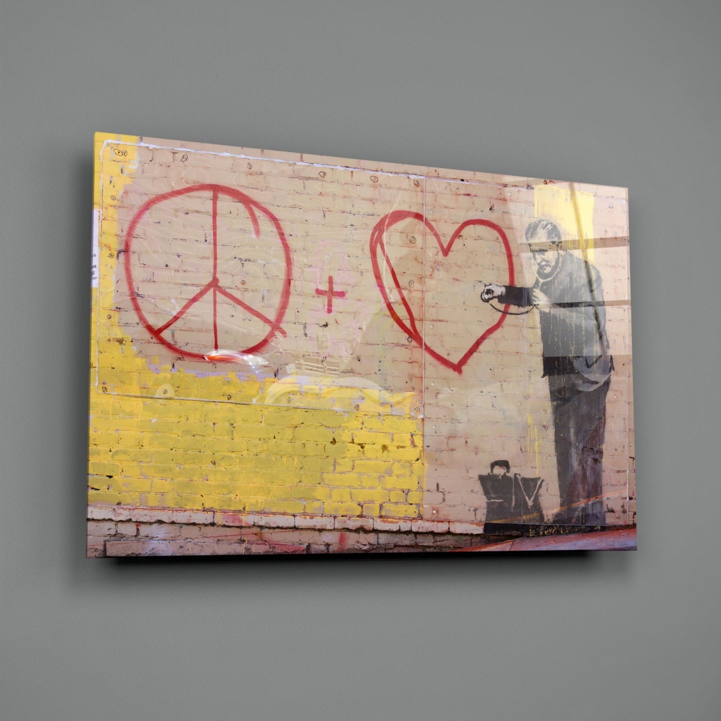 Glass art print of brick wall with red peace symbol and heart, yellow stripe, and stenciled figure holding spray can.