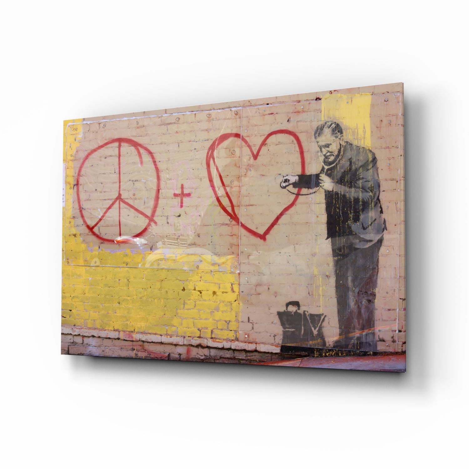 Canvas print of stenciled figure in dark coat drawing red peace sign and heart on pink brick wall with yellow painted section.