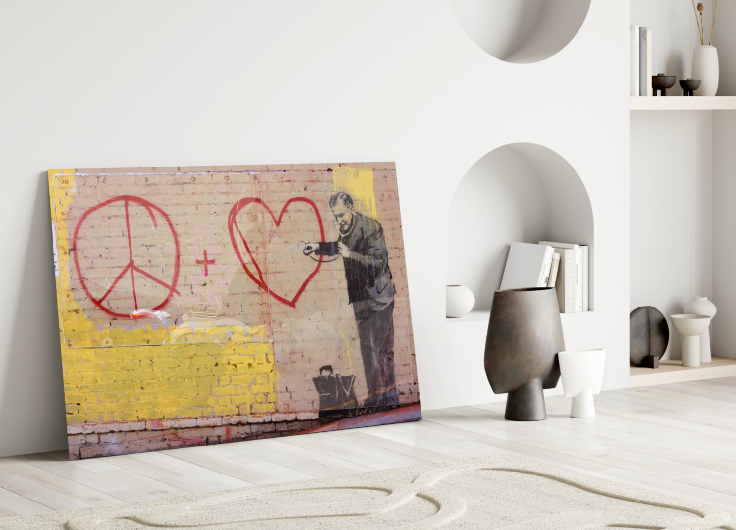 Street art glass panel featuring red peace symbol and heart with stenciled figure leaning right, yellow lower section, displayed against white wall with ceramic vessels.