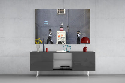 Framed glass art depicting urban street scene with stenciled figures and "FREE DOLLAR" text displayed above modern media console.
